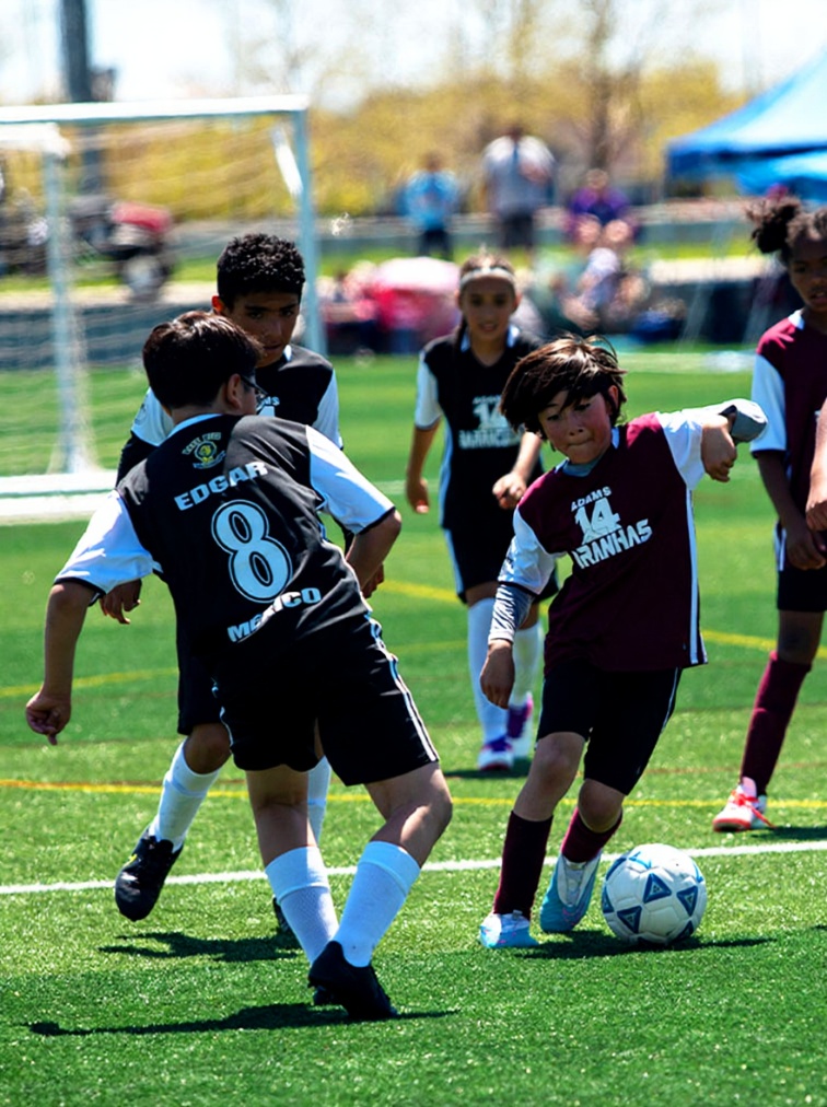 Young Boy Dribbling In Youth Soccer Game